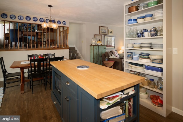 kitchen featuring dark wood-type flooring, blue cabinets, hanging light fixtures, butcher block countertops, and a notable chandelier