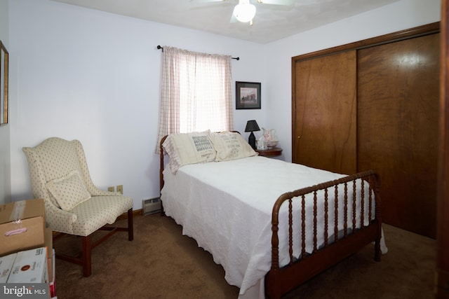 bedroom with dark colored carpet, a closet, ceiling fan, and a baseboard heating unit