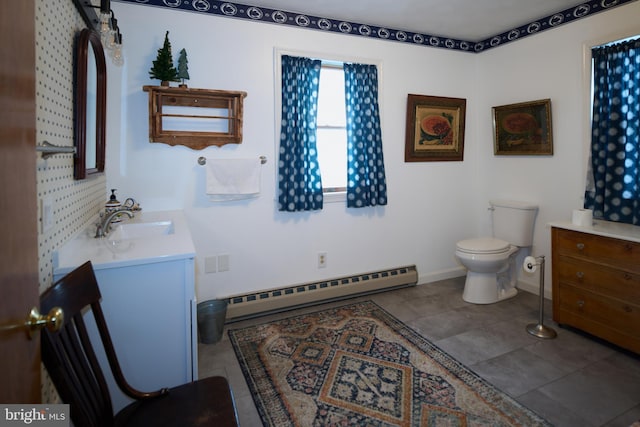 bathroom with toilet, vanity, and a baseboard heating unit