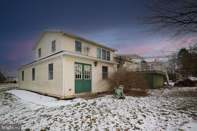 snow covered property with a deck