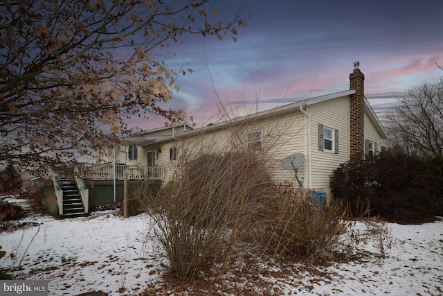 view of snowy exterior with a wooden deck