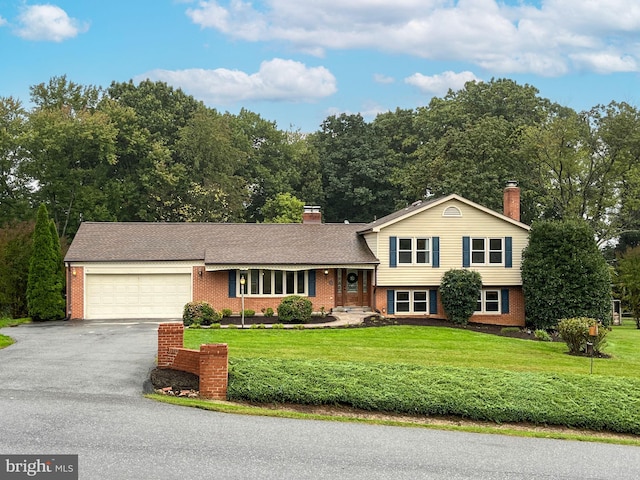 split level home featuring a garage and a front yard