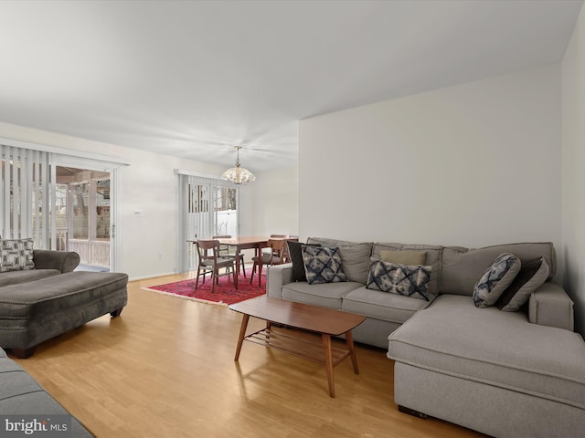 living room with light wood-type flooring and a notable chandelier