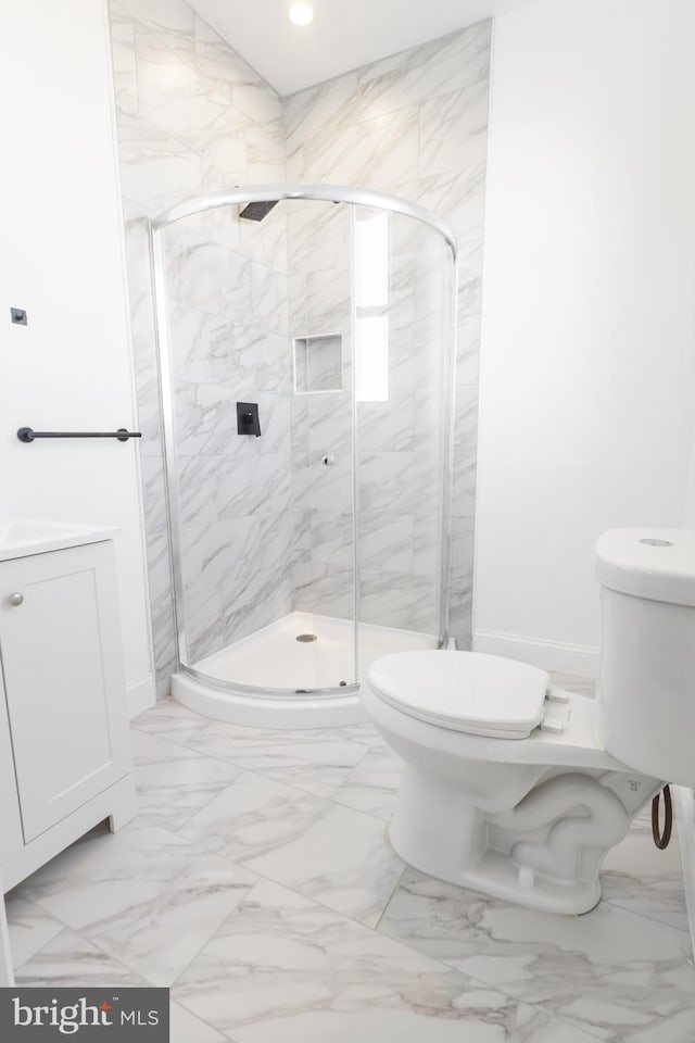 bathroom featuring vanity, toilet, and a shower with shower door