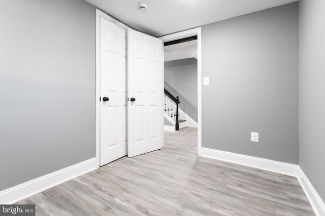 unfurnished bedroom featuring light hardwood / wood-style floors and a closet