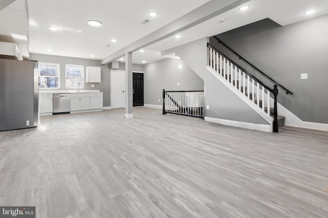 unfurnished living room with light hardwood / wood-style flooring and sink