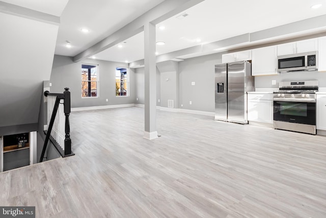 kitchen with white cabinetry, beamed ceiling, light hardwood / wood-style floors, and appliances with stainless steel finishes