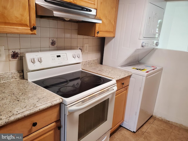 kitchen with white electric range, stacked washer / dryer, light stone countertops, decorative backsplash, and light tile patterned flooring