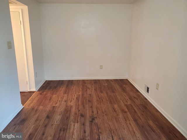 spare room with dark wood-type flooring