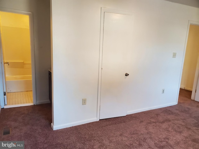 unfurnished bedroom with dark carpet