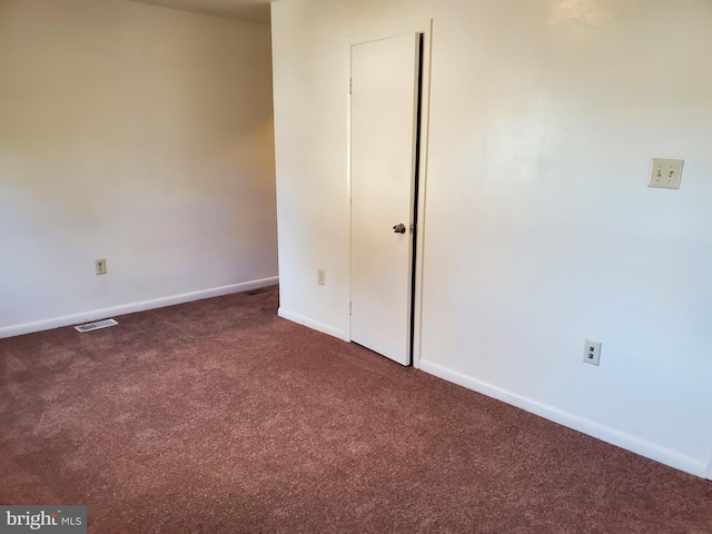 empty room with dark colored carpet