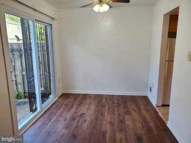 empty room featuring a textured ceiling, ceiling fan, and dark hardwood / wood-style floors