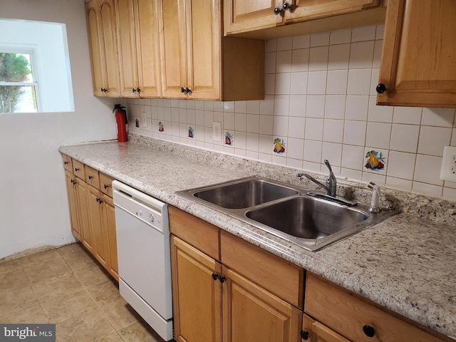 kitchen with sink, white dishwasher, and backsplash