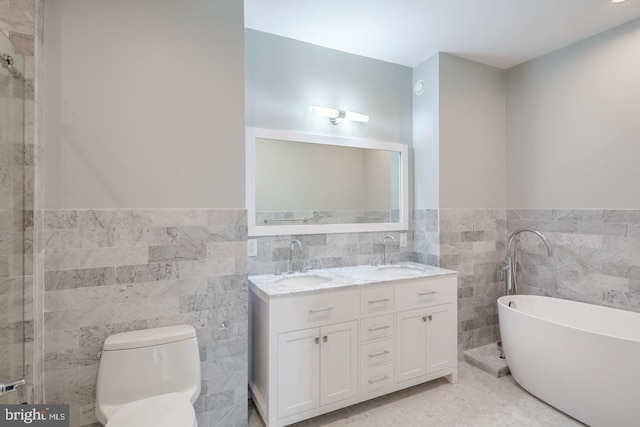 bathroom featuring vanity, toilet, tile walls, and a bathing tub