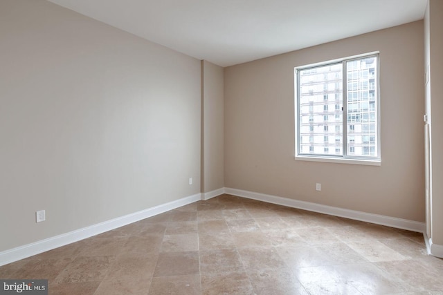 unfurnished room featuring plenty of natural light and baseboards