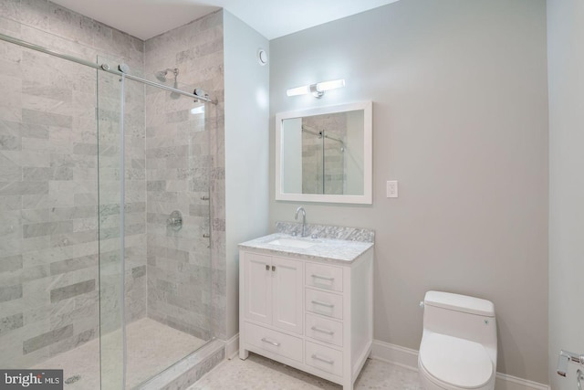 bathroom featuring a stall shower, baseboards, vanity, and toilet