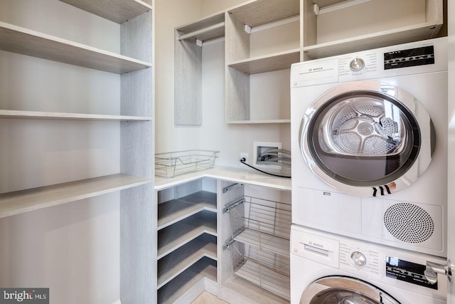 laundry area with stacked washer / drying machine and laundry area