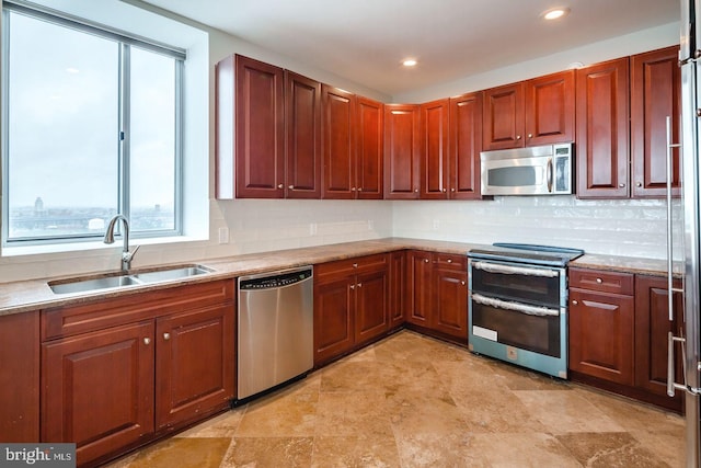 kitchen with decorative backsplash, light stone countertops, sink, and stainless steel appliances