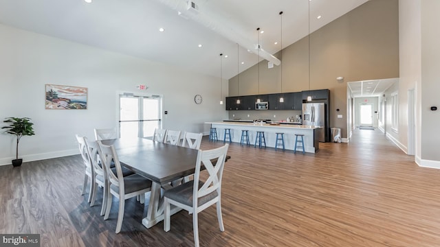 dining room featuring hardwood / wood-style floors and a towering ceiling