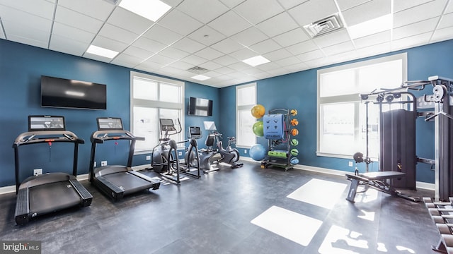 gym featuring plenty of natural light and a drop ceiling