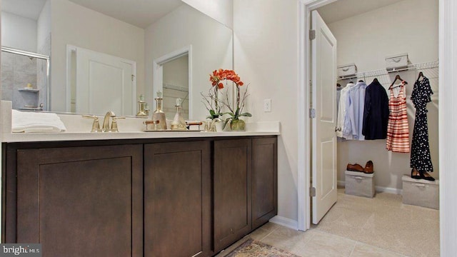 bathroom with tile patterned floors, vanity, and an enclosed shower