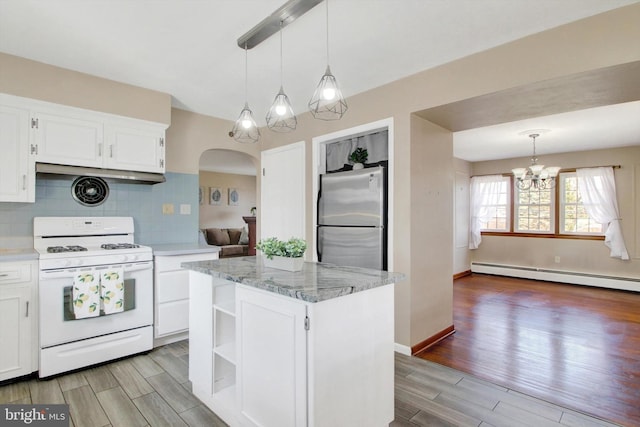 kitchen with wood tiled floor, freestanding refrigerator, baseboard heating, and white gas stove