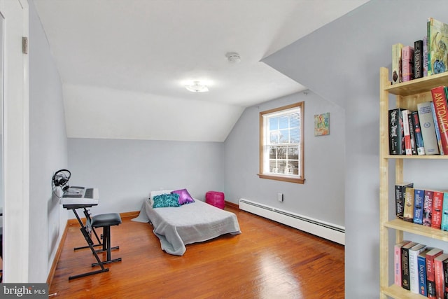 bedroom with a baseboard heating unit, vaulted ceiling, baseboards, and wood finished floors