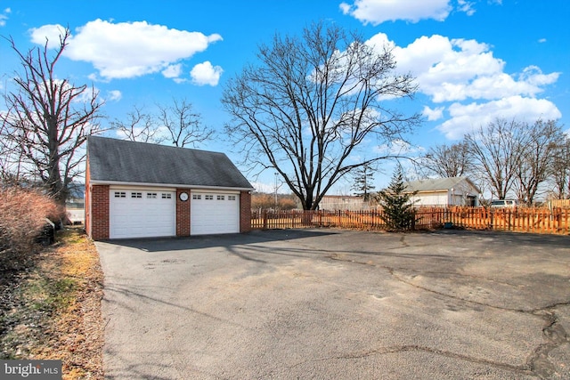 detached garage featuring fence