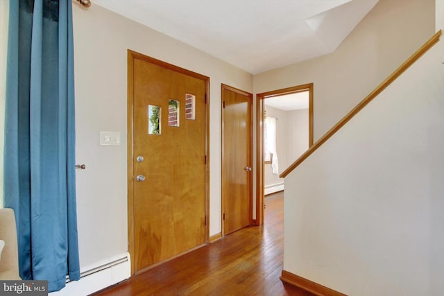 foyer with a baseboard radiator, baseboards, and wood finished floors