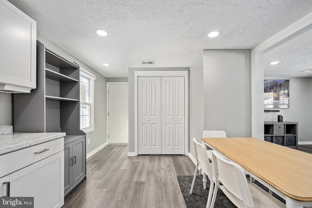 dining space featuring light hardwood / wood-style floors and a textured ceiling