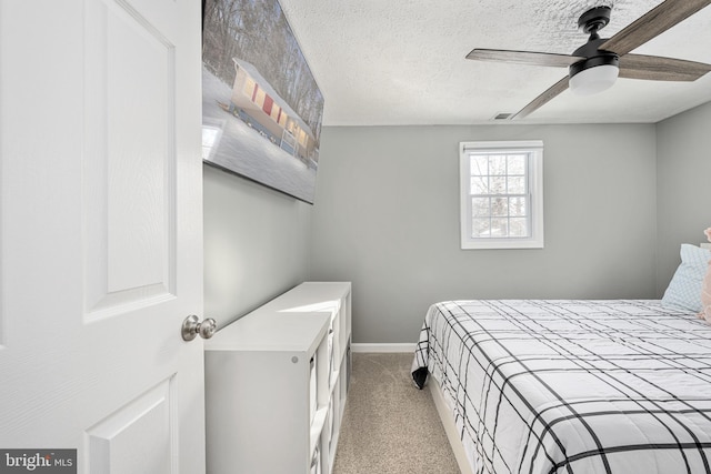 carpeted bedroom with a textured ceiling and ceiling fan