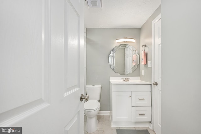 bathroom featuring vanity, a textured ceiling, and toilet