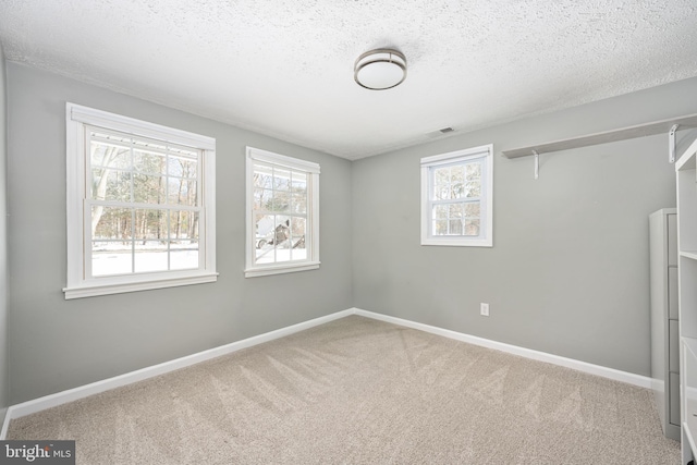 unfurnished room with carpet flooring and a textured ceiling