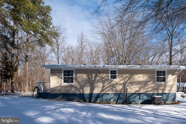 snow covered rear of property with cooling unit