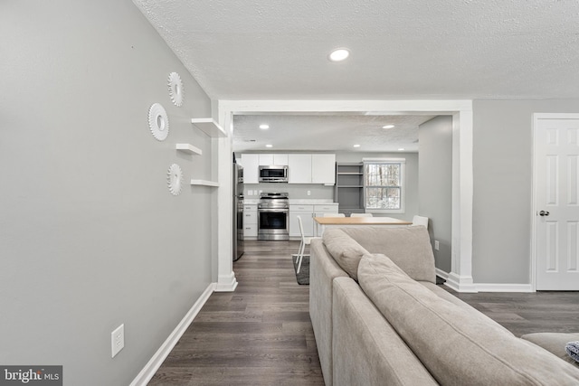 living room with dark hardwood / wood-style flooring and a textured ceiling