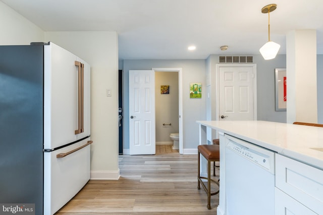 kitchen featuring light wood-type flooring, white cabinets, high quality fridge, pendant lighting, and dishwasher