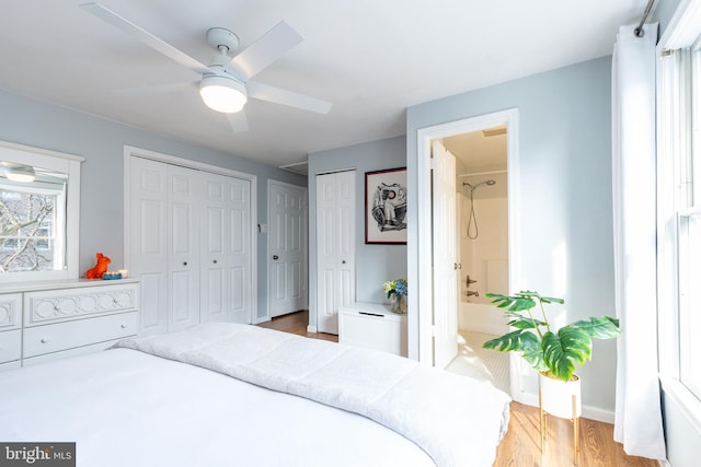 bedroom featuring multiple closets, ceiling fan, and hardwood / wood-style floors