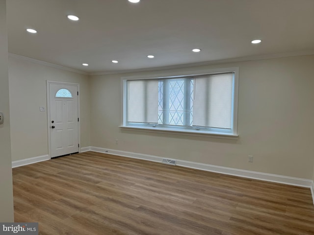 entryway with crown molding, lofted ceiling, and hardwood / wood-style flooring