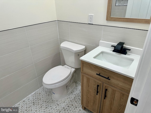 bathroom featuring tile patterned floors, vanity, tile walls, and toilet