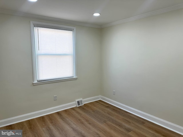 spare room featuring wood-type flooring and ornamental molding