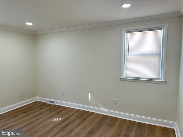 unfurnished room featuring dark wood-type flooring and ornamental molding