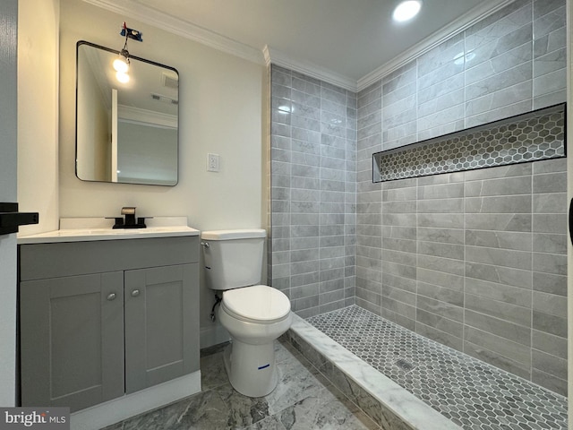 bathroom featuring vanity, toilet, ornamental molding, and tiled shower