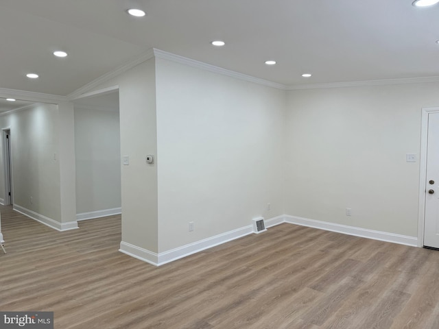 spare room featuring light hardwood / wood-style floors and ornamental molding