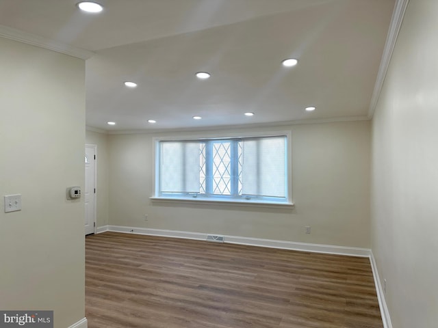 unfurnished room with crown molding and dark wood-type flooring