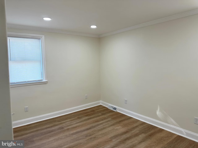 spare room with dark hardwood / wood-style floors and crown molding