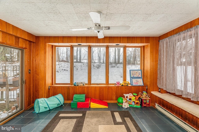 sunroom / solarium with a baseboard heating unit, plenty of natural light, and ceiling fan