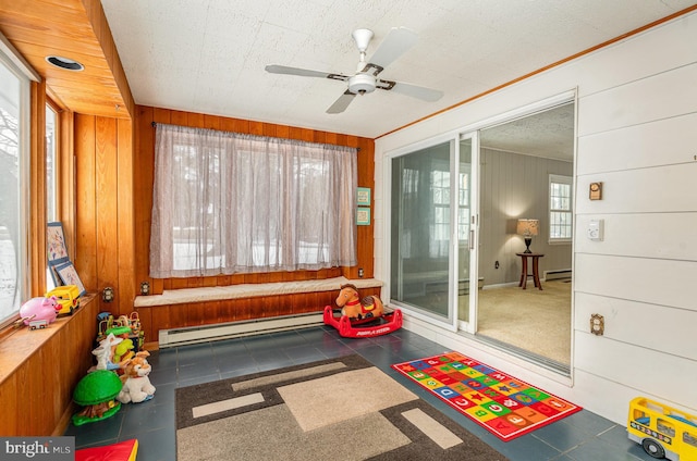 sunroom featuring a baseboard radiator and ceiling fan