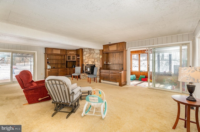 living room featuring wooden walls, carpet, a textured ceiling, and baseboard heating