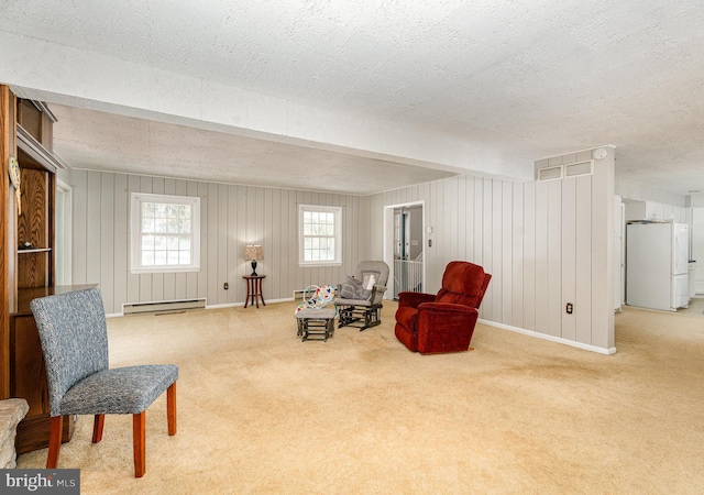 sitting room with beam ceiling, carpet, a textured ceiling, and baseboard heating