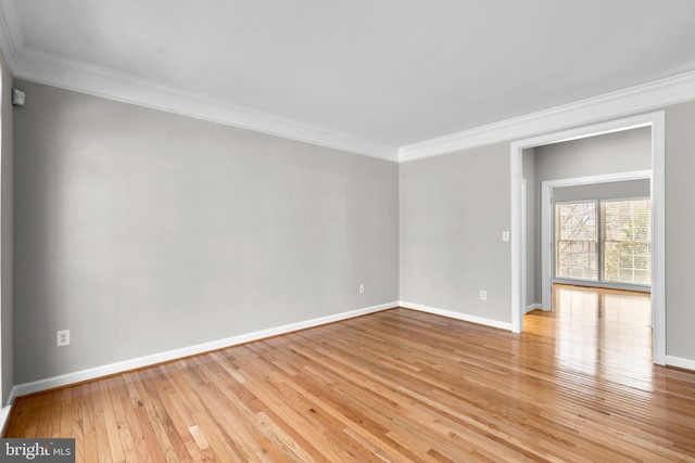 unfurnished room featuring light wood-style flooring, baseboards, and ornamental molding